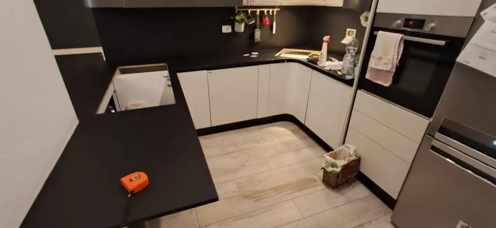 Penisola cucina rivestita con pellicola adesiva effetto legno durante restyling cucina a Roma