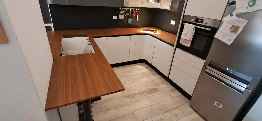 Penisola cucina rivestita con pellicola adesiva effetto legno durante restyling cucina a Roma